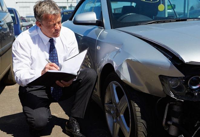 broken windshield with car insurance paperwork